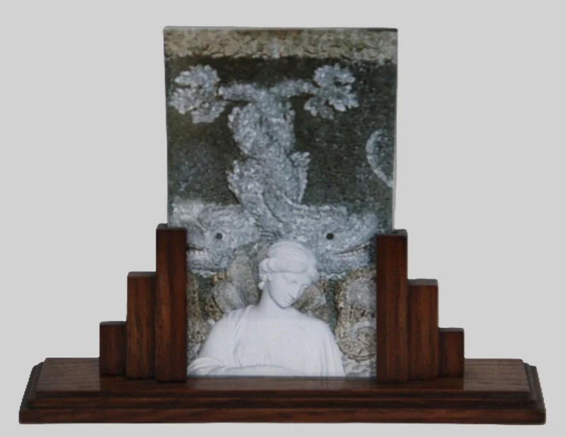 Art Déco houten fotolijst - Diversen › Varia - €25.00 - Fotolijst met houten onderstel in eik en inschuifbare dubbele glasplaat als fotohouder.
voet: 20cm breed
glasplaat 16cm hoog