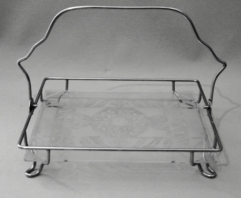 Draagbaar rekje - Zilver › Plateau's - Plateau in verzilverd frame en een blad in geëtst glas.
24 x 19cmNeerklapbare hendel.
Ca 1930-1950