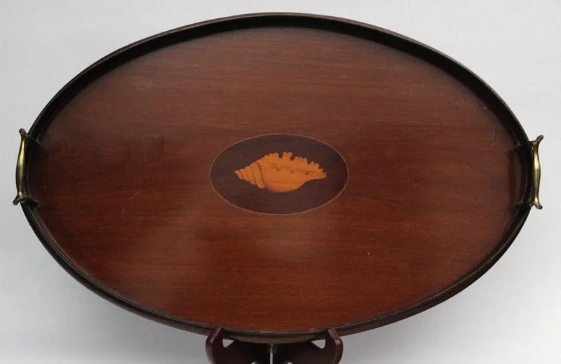 Edwardian mahoniehouten dienblad - Diversen › Varia - €135.00 - Ovaal houten dienblad met houten galerij en messing handgrepen. Centraal ingelegd met satijnhout in de vorm van een schelp.
59 x 38cm
Edwardian periode, ca 1910/1930