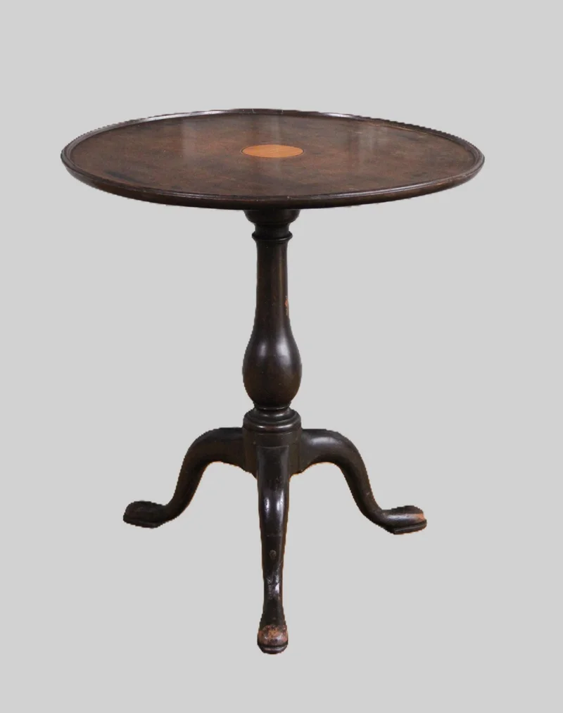 Georgean wijntafeltje - Meubel › Bijzetmeubel - €295.00 - Rond bijzettafeltje in cubaans mahoniehout met centraal in inlegstukje in satijnhout. 
Georgean periode; ca 1770
56cm hoog; 52cm diameter