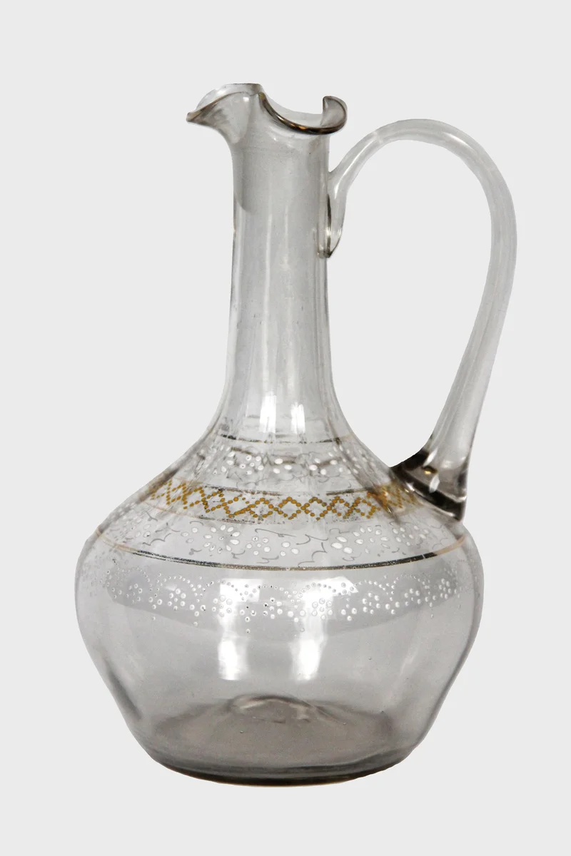 Glazen schenkkaraf met goudversiering - Glas › Karaffen - €15.00 - Schenkkannetje in mondgeblazen glas met versierde rand in goud en wit.
19cm hoog.
vroeg 20e eeuw.