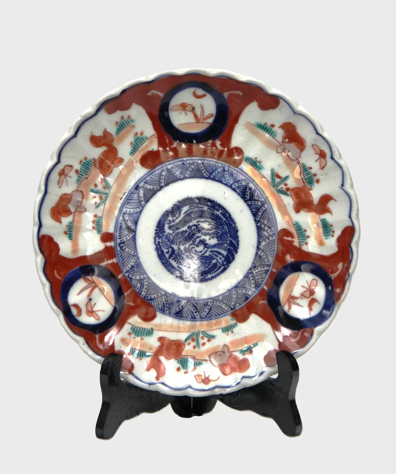 Imari bord (8) - Porselein › Borden - Bord met rood-blauwe versiering. Ook versierd op achterrand.
22cm diameter
Vroege 20e eeuw