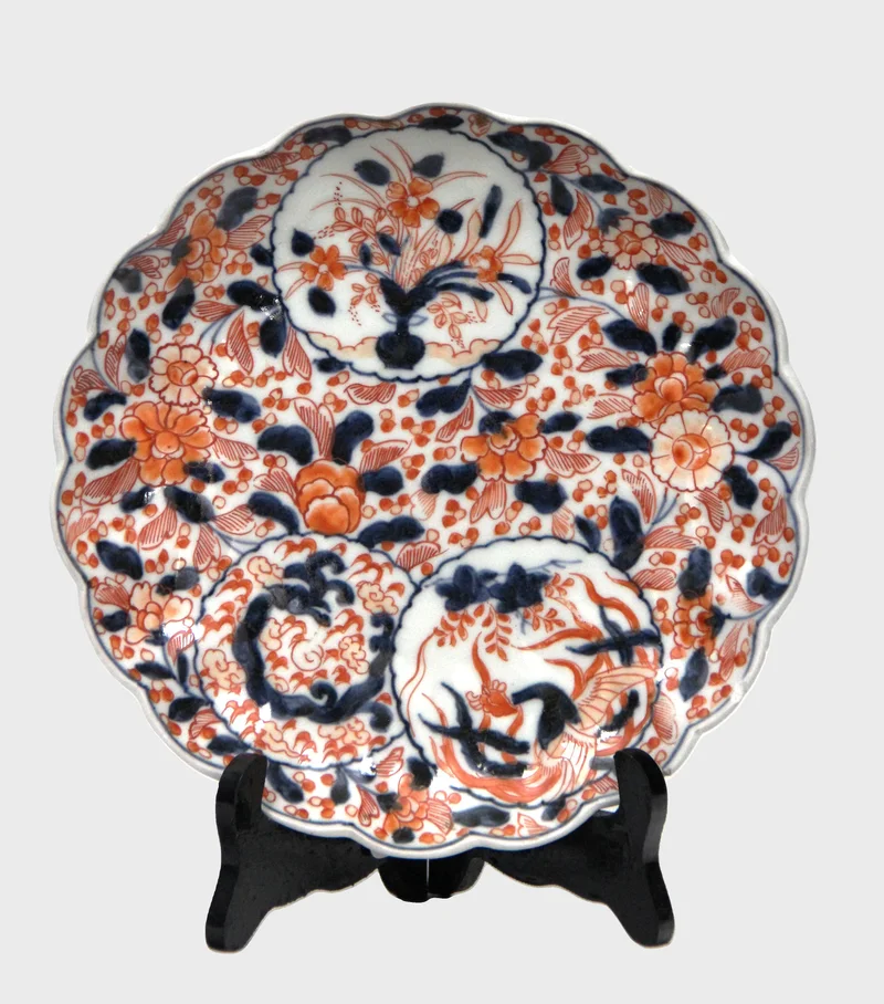Imari bord (9) - Porselein › Borden - €35.00 - Bord met rood-blauwe versiering en blauwe versiering op de achterrand. Gelobde rand.
22.5cm diameter
Vroege 20e eeuw