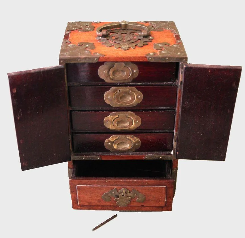 Oosters juwelendoosje - Diversen › Dozen en kistjes - €225.00 - Vroeg 20e eeuws juwelenkistje met verschillende kleine laden. Roodhout  met koper beslag.
16.5 x 13 cm   25cm hoog.