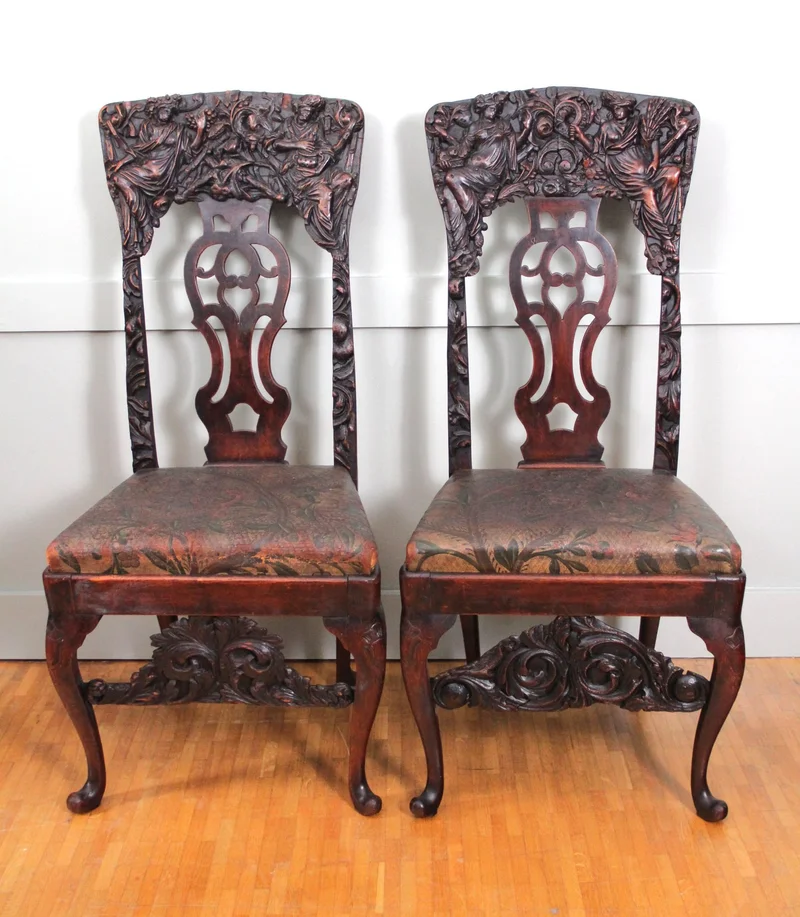 Paar 18e eeuwse halstoelen - Meubel › Zitmeubels - €1750.00 - Paar "paradestoelen" uit de vroege 18e eeuw in notenhout met rijk gesculpteerde ruggen en oorspronkelijk goudleder op de zittingen.
Opengewerkte rugplaat in Georgean stijl.
Early-Georgean periode: 1720-1740
110cm hoog, 50cm breed, 45cm diep.