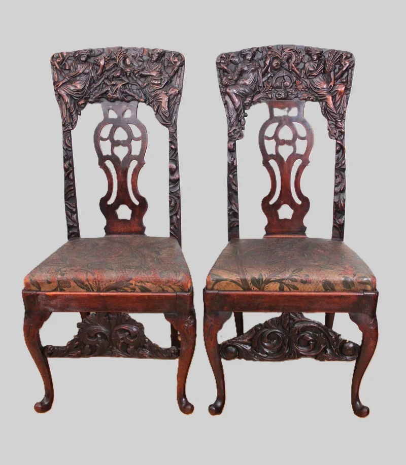 Paar 18e eeuwse halstoelen - Meubel › Zitmeubels - €1750.00 - Paar "paradestoelen" uit de vroege 18e eeuw in notenhout met rijk gesculpteerde ruggen en oorspronkelijk goudleder op de zittingen.
Opengewerkte rugplaat in Georgean stijl.
Early-Georgean periode: 1720-1740
110cm hoog, 50cm breed, 45cm diep.