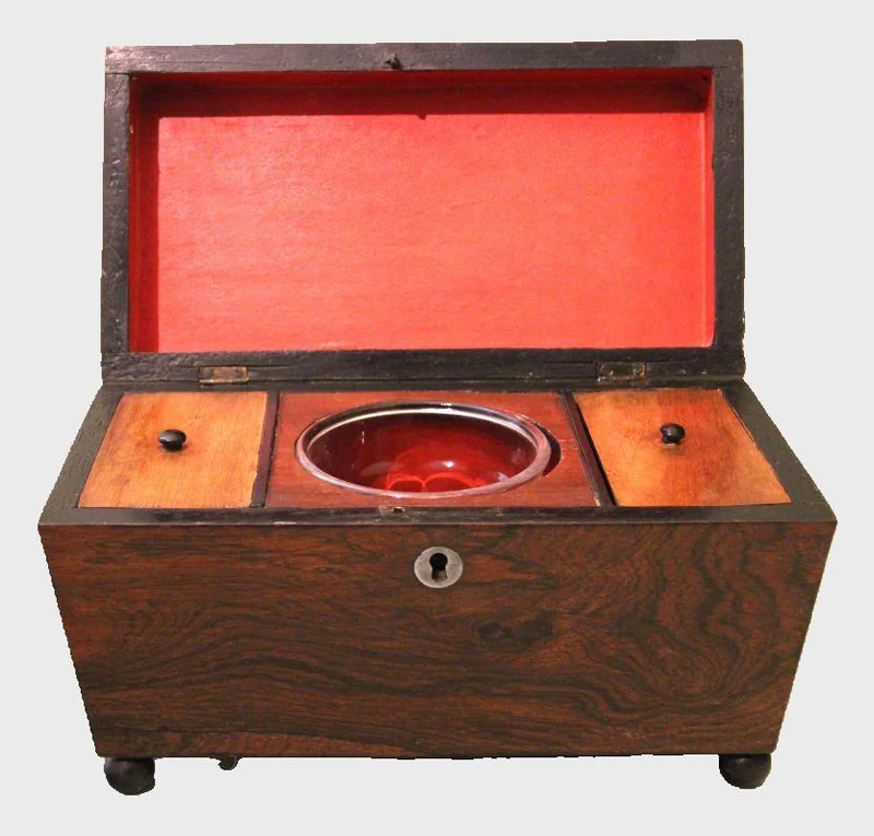 Palissander theacaddy - Diversen › Dozen en kistjes - €195.00 - Georgean theacaddy in palissanderhout. Binnenin twee theevakjes naast een centraal geplaatst mengglas. Mengglas later vervangen.
27.5 x 13cm   17cm hoog
Ca 1800