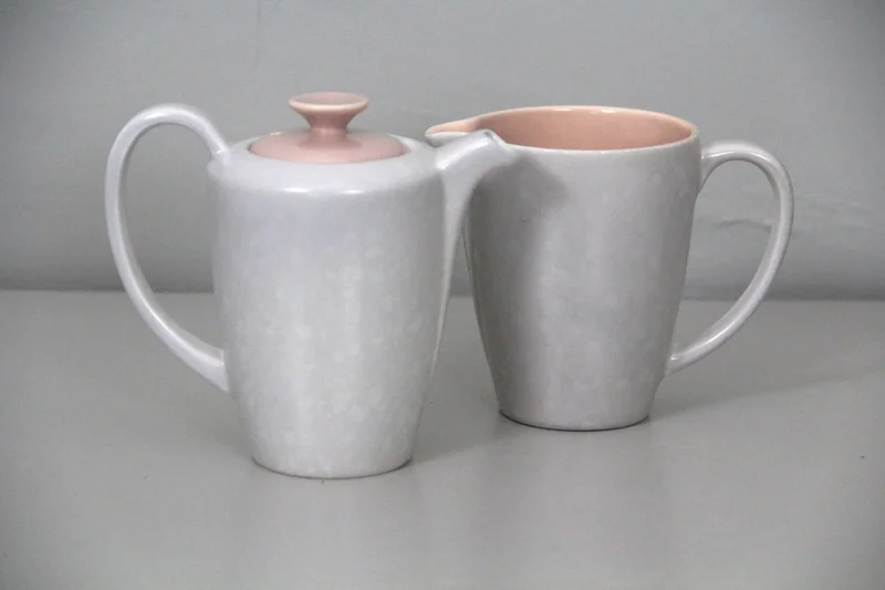 Poole koffie- en roomkan - Porselein › Serviesgoed - Koffiepotje en roomkan, gemerkt: Poole
Engelse makelij
Buitenkant parelmoermotief, binnenkant roze.
Periode 1960/1970