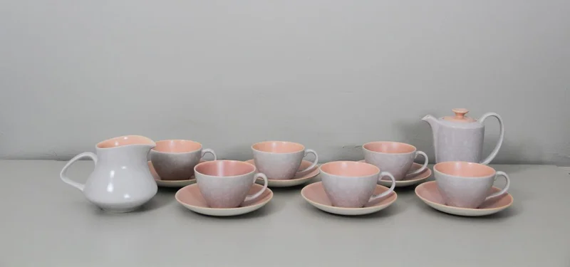 Poole servies - Porselein › Serviesgoed - Set van 6 theetassen met ondertas, theepotje en roomkan.
Decor buitenkant: parelmoermotief
Decor binnenkant: roze
Engeland, gemerkt Poole
Periode 1960/1970