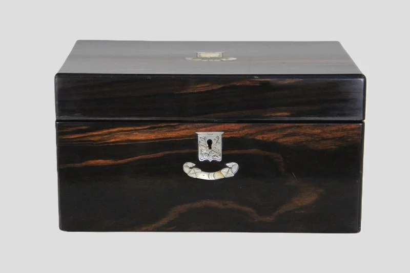 Rechthoekige doos in coromandel - Diversen › Dozen en kistjes - €195.00 - Grote rechthoekige doos, gefineerd in coromandel en op het deksel en rond het sleutelgat ingelegd met gegraveerd parelmoer.
28 x 20cm, 14.5cm hoog
Vroege 19e eeuw; Georgean periode
