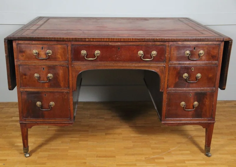 Regency partnerdesk - Meubel › Tafels - €1500.00 - Mahoniehouten partnerdesk met aan de ene zijde 6 laden en aan de andere zijde 3 laden en twee kastjes.
Opklapbare bladen aan beide zijden.
Origineel leder met goudrand indruk.
91cm diep, 119cm breed, opklapbaar tot 183cm, 75cm hoog.

Regency periode, ca 1820