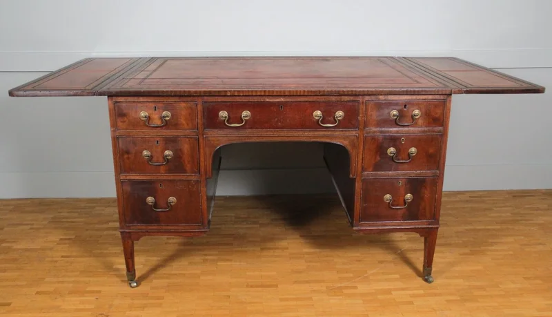 Regency partnerdesk - Meubel › Tafels - €1500.00 - Mahoniehouten partnerdesk met aan de ene zijde 6 laden en aan de andere zijde 3 laden en twee kastjes.
Opklapbare bladen aan beide zijden.
Origineel leder met goudrand indruk.
91cm diep, 119cm breed, opklapbaar tot 183cm, 75cm hoog.

Regency periode, ca 1820