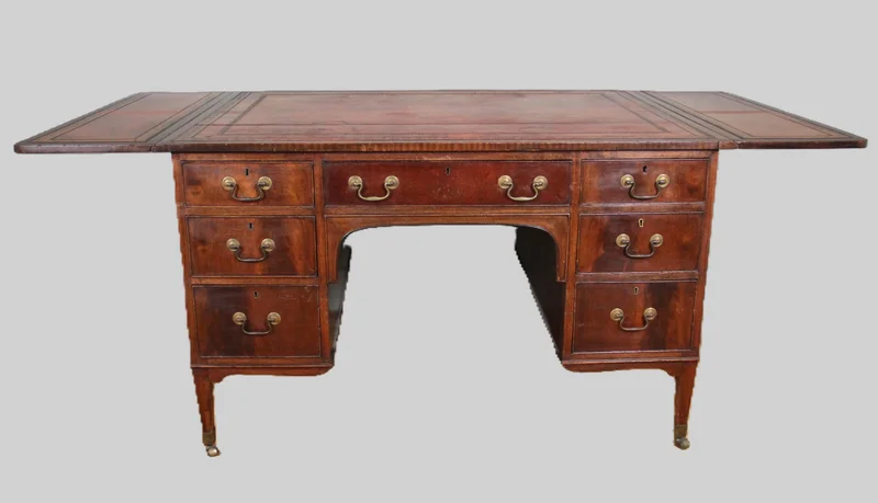 Regency partnerdesk - Meubel › Tafels - €1500.00 - Mahoniehouten partnerdesk met aan de ene zijde 6 laden en aan de andere zijde 3 laden en twee kastjes.
Opklapbare bladen aan beide zijden.
Origineel leder met goudrand indruk.
91cm diep, 119cm breed, opklapbaar tot 183cm, 75cm hoog.

Regency periode, ca 1820