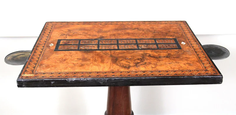 Regency speeltafel - Meubel › Tafels - Speeltafel met mahonie voet en speelblad in notenhout en sierrand in marqueterie. Onder het blad twee scharnierende koperen kandelaarhouders.
Regency periode, ca 1820

€