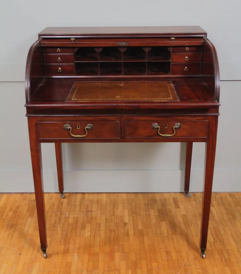 Rolluikbureautje - Meubel › Bijzetmeubels - Mahoniehouten rolluikbureautje met uitschuifbaar en opklapbaar schrijfblad, diverse binnenladen en pigeonholes. Twee uitschuifbare legplankjes aan de zijkanten. Originele castors.
76 x 57cm; 96cm hoog.
Georgean stijl; Edwardian periode; ca 1930