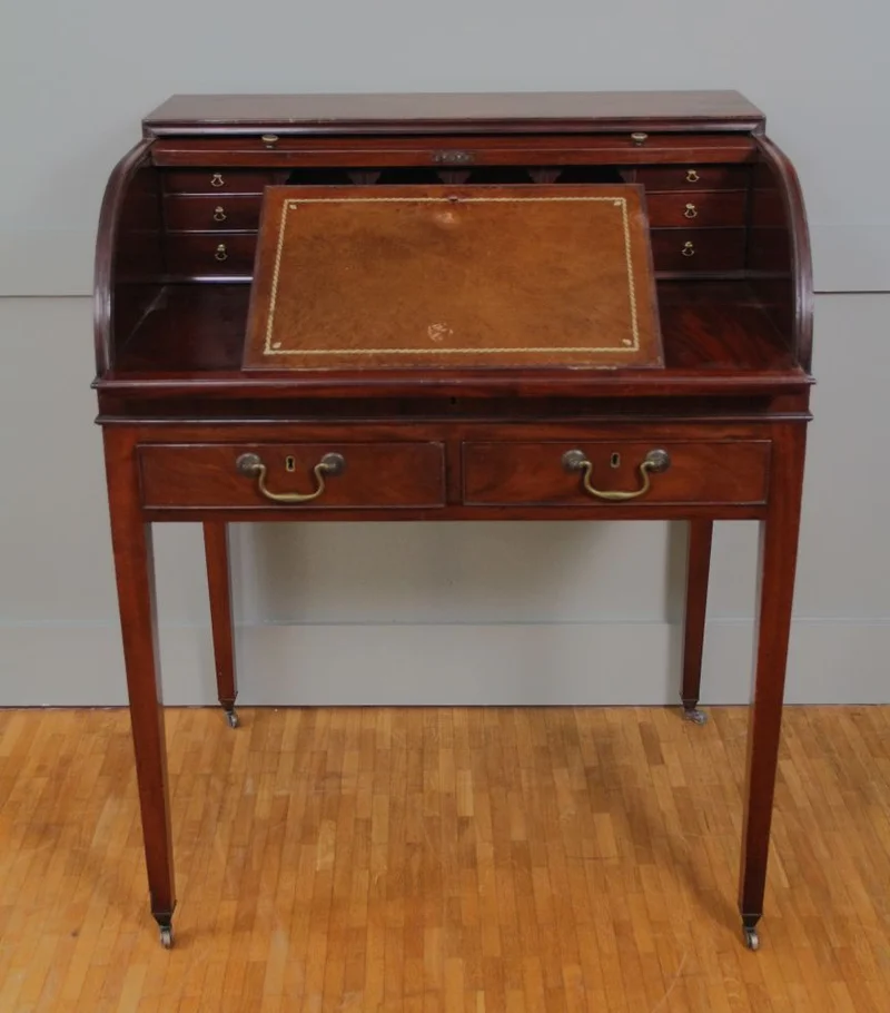 Rolluikbureautje - Meubel › Bijzetmeubels - Mahoniehouten rolluikbureautje met uitschuifbaar en opklapbaar schrijfblad, diverse binnenladen en pigeonholes. Twee uitschuifbare legplankjes aan de zijkanten. Originele castors.
76 x 57cm; 96cm hoog.
Georgean stijl; Edwardian periode; ca 1930