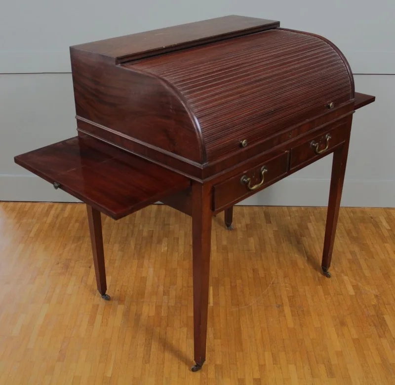 Rolluikbureautje - Meubel › Bijzetmeubels - Mahoniehouten rolluikbureautje met uitschuifbaar en opklapbaar schrijfblad, diverse binnenladen en pigeonholes. Twee uitschuifbare legplankjes aan de zijkanten. Originele castors.
76 x 57cm; 96cm hoog.
Georgean stijl; Edwardian periode; ca 1930