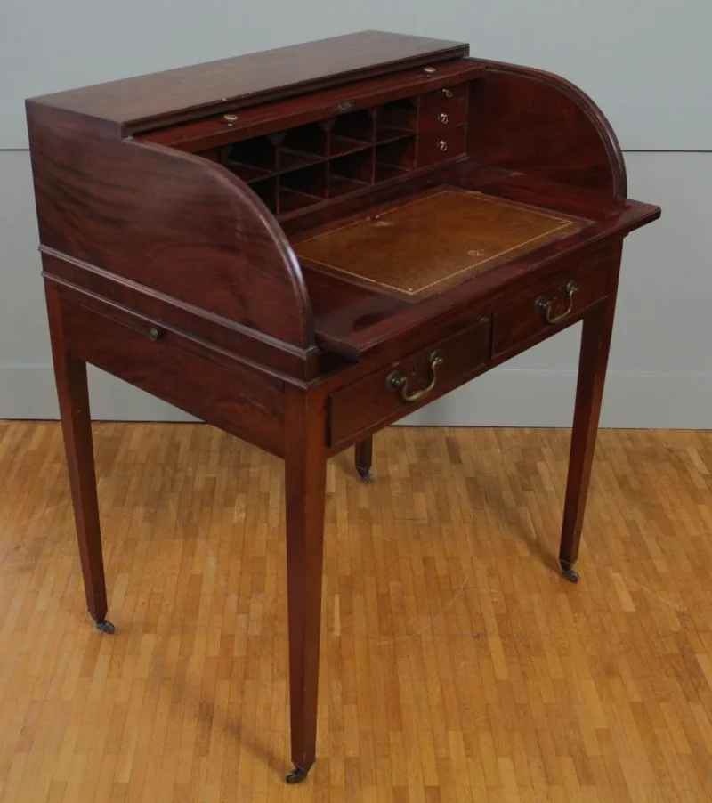 Rolluikbureautje - Meubel › Bijzetmeubels - Mahoniehouten rolluikbureautje met uitschuifbaar en opklapbaar schrijfblad, diverse binnenladen en pigeonholes. Twee uitschuifbare legplankjes aan de zijkanten. Originele castors.
76 x 57cm; 96cm hoog.
Georgean stijl; Edwardian periode; ca 1930