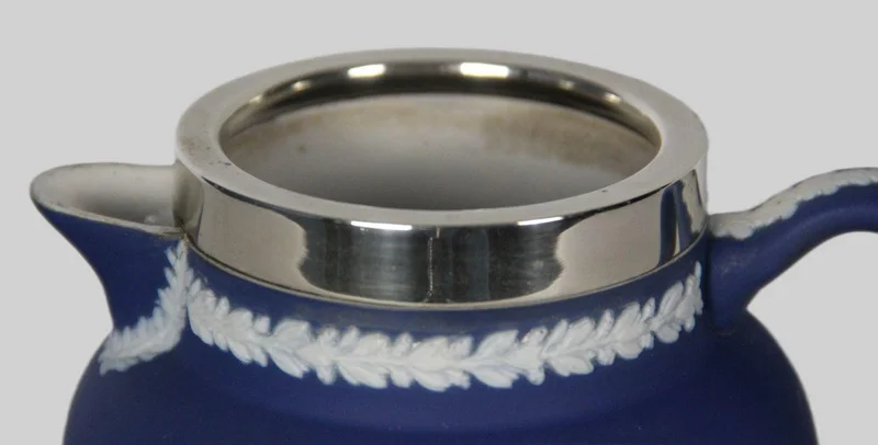 Roomkan in Wedgewood motief (1) - Porselein › Serviesgoed - €40.00 - Een roomkan met decoratie in Wedgewood stijl. Een verzilverde kraag.
Gemerkt: Tunstall England, Adam
12cm hoog
19e eeuw