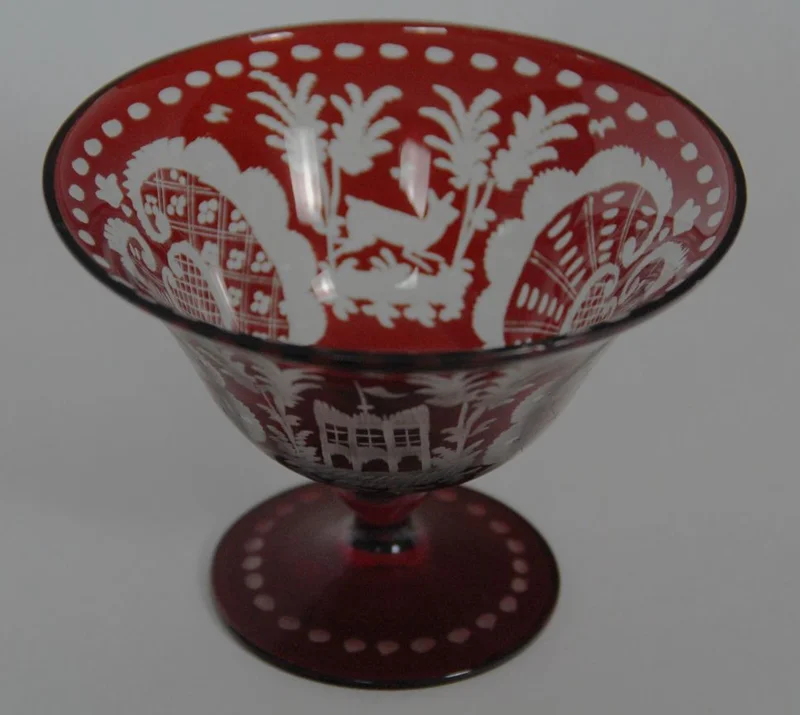 Schaaltje in Boheems glas - Glas › Schalen - €15.00 - Klein schaaltje op voet in Boheems glas met typische rode decoratie in neo-rococo stijl.
11.5cm diameter, 8.5cm hoog
Vroege 20e eeuw