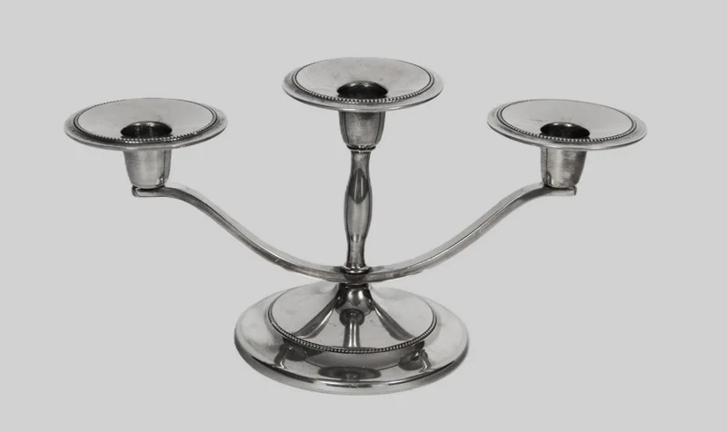 Tafelkandelaartje - Zilver › Kandelaars - Een kleine kandelaar voor 3 kaarsen.
Gemerkt: Plate, Made in England
12,5cm hoog; 24cm breed
Midden 20e eeuw