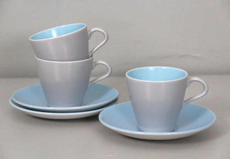Trio koffietassen Poole - Porselein › Serviesgoed - Set van drie tassen met ondertas, gemerkt Poole.
Parelmoer-blauw decor.
Engeland.
Periode 1960/1970