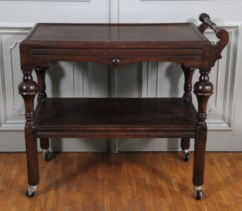 Trolley  - Meubel › Bijzetmeubel - €225.00 - Eikenhouten dienwagen op originele wielen.
Twee dienbladen.
80 x 42cm; 73cm hoog; onderste dienblad op 33cm hoogte en bovenste dienblad op 68cm hoogte.
Nederlandse makelij
ca 1930/1940